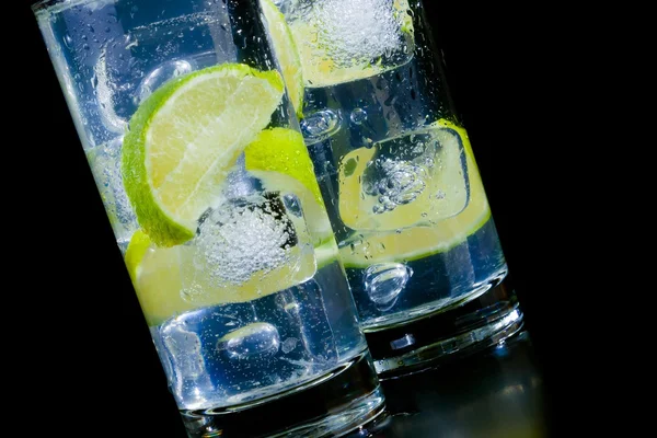 Siyah masa üstünde buz ve limon dilim taze kokteyl — Stok fotoğraf