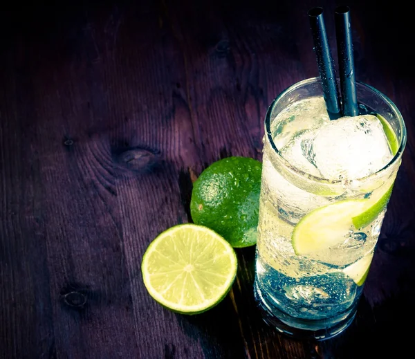 Cocktail with ice and lime slice and space for text, club atmosphere — Stock Photo, Image