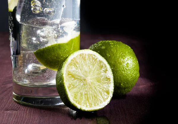 Cocktail with ice and lime slice and space for text — Stock Photo, Image