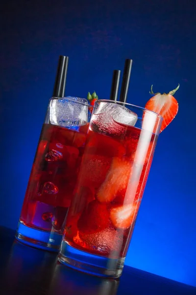 Dos vasos de cóctel de fresa con hielo en la mesa de madera — Foto de Stock