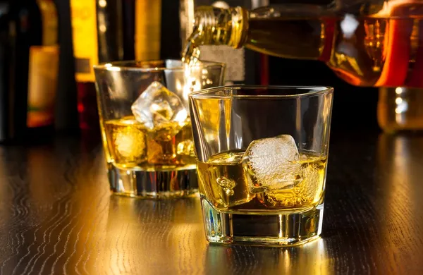 Barman gieten whisky achter whisky glas — Stockfoto