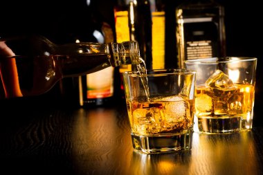 Barmen odak üstünde belgili tanımlık tepe-in şişe viski şişeleri önüne dökülen