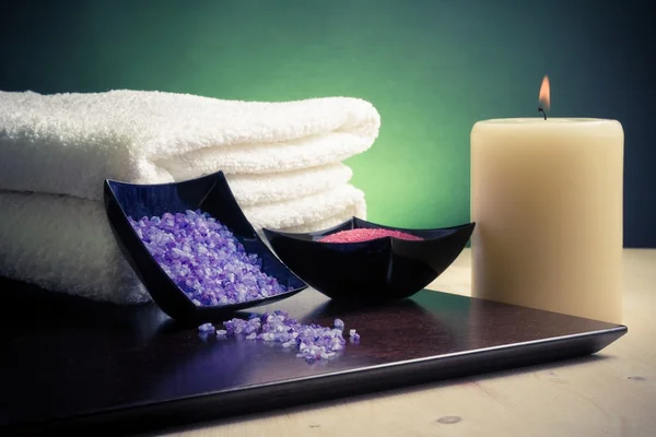 Wellness massage grens achtergrond met handdoek gestapeld, kaars en zee zout — Stockfoto