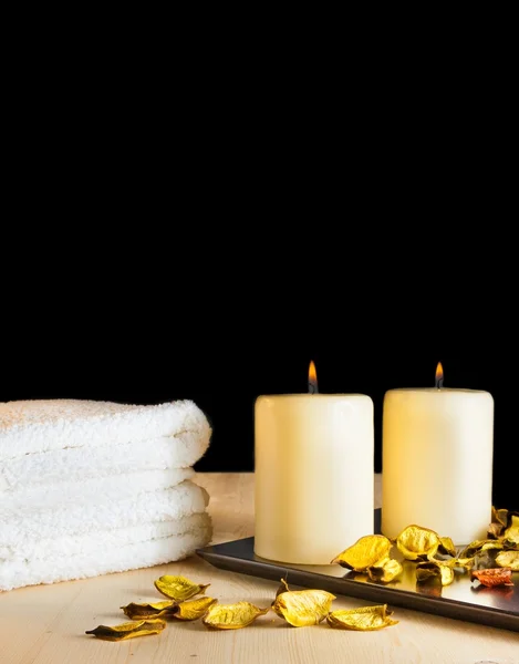 Spa massage gränsen bakgrund med handduk staplade, parfymerade blad och ljus — Stockfoto