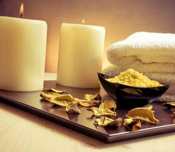 Spa massaggio bordo sfondo con asciugamano impilato, foglie profumate, candela e sale marino — Foto Stock