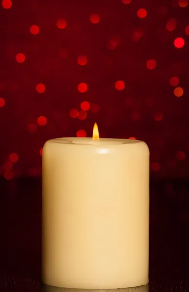 Свеча с пламенем на деревянном столе — стоковое фото
