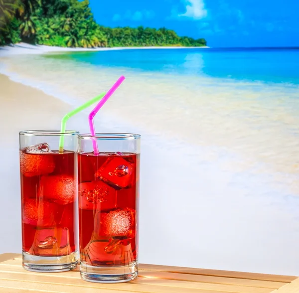 Twee glazen van rode cocktail met vervagen strand en ruimte voor tekst — Stockfoto