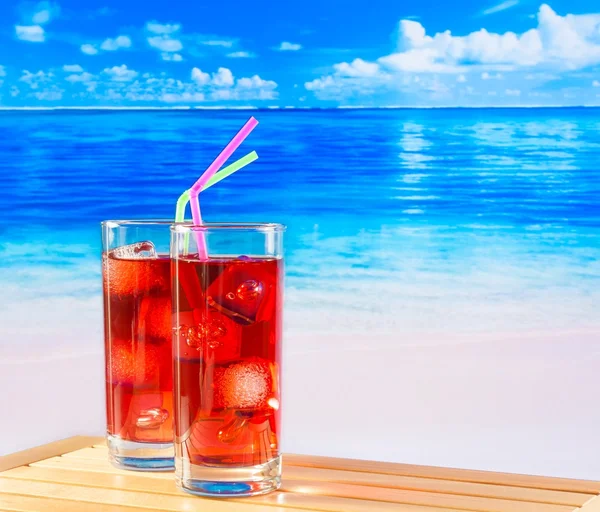 Glazen rode cocktail met vervagen strand — Stockfoto