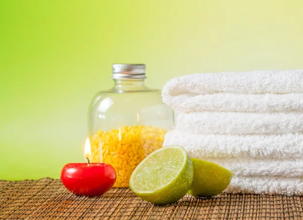 Spa massage gränsen bakgrunden med handduk staplade, rött ljus och lime — Stockfoto