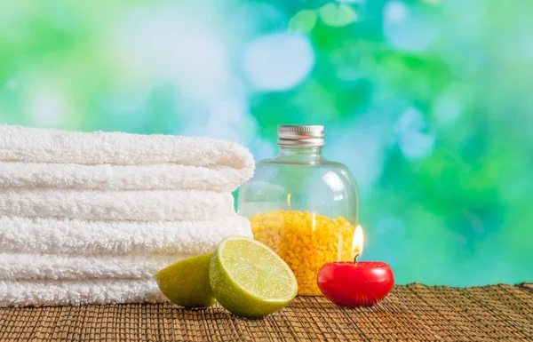 Spa massage bordure fond avec serviette empilée, bougie rouge et citron vert — Photo