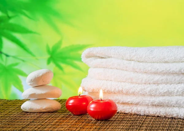 Fondo de borde de masaje spa con toalla apilada, velas rojas y piedra —  Fotos de Stock