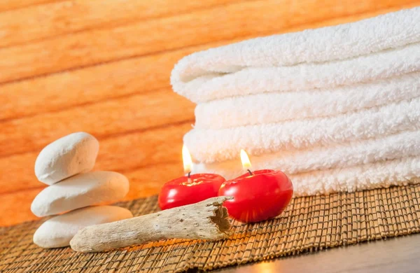 Spa massage bordure fond avec serviette empilée pierre et bougies rouges — Photo