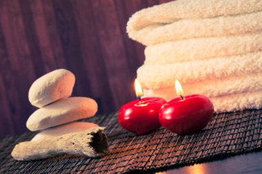 Spa Masaj sınır arka plan ile taş yığılmış havlu ve sıcak bir atmosfer kırmızı mumlar