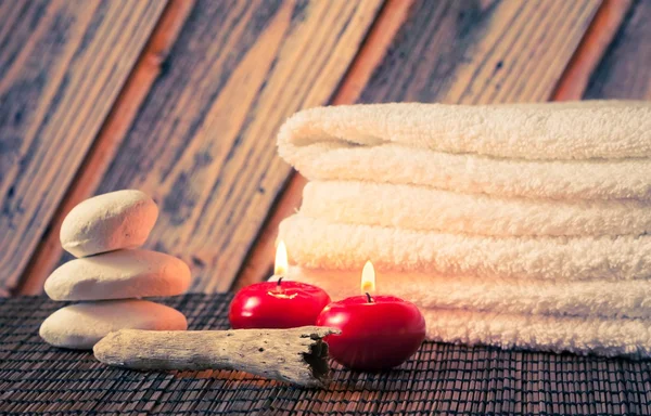 Spa massage gränsen bakgrunden med handduk staplad sten och rött ljus — Stockfoto