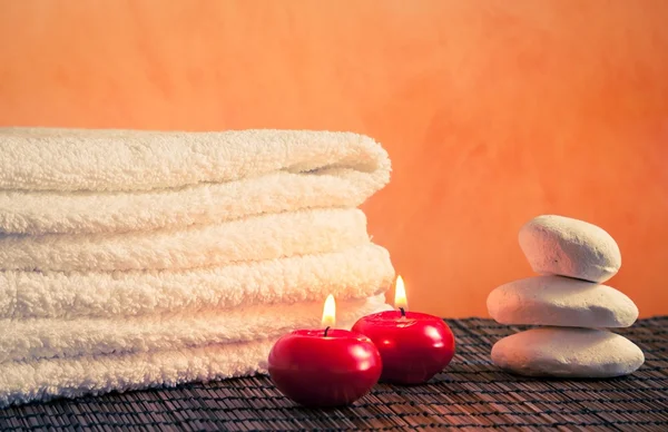 Спа массаж границы фона с полотенцем укладывается камень и красные свечи — стоковое фото