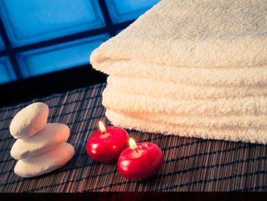 Spa Masaj sınır arka plan ile taş yığılmış havlu ve sıcak bir atmosfer kırmızı mumlar