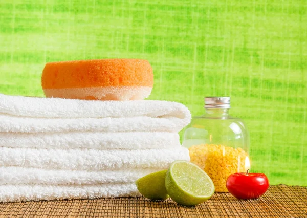 Spa massage bordure fond avec serviette empilée, bougie rouge et citron vert — Photo