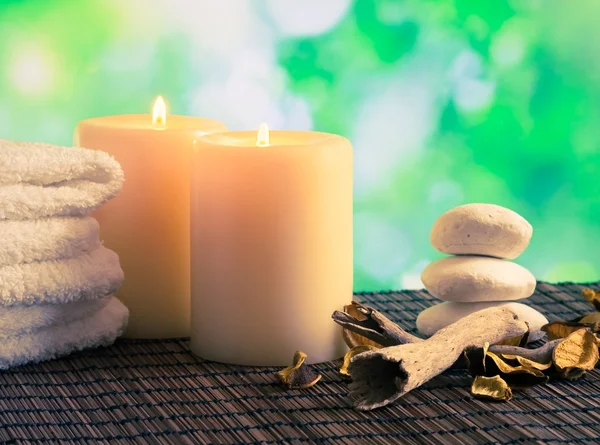 Wellness massage grens achtergrond met handdoek gestapeld, kaarsen en steen — Stockfoto