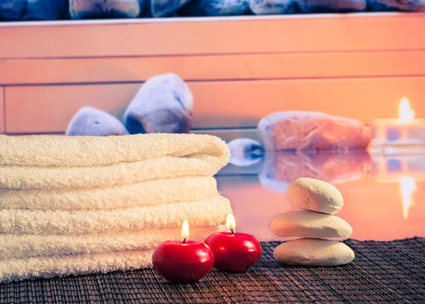 Frontera de masaje spa con toalla apilada, velas rojas cerca de piedra — Foto de Stock