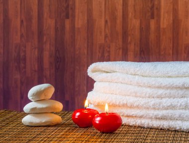 Spa Masaj sınır arka plan ile taş yığılmış havlu ve sıcak bir atmosfer kırmızı mumlar
