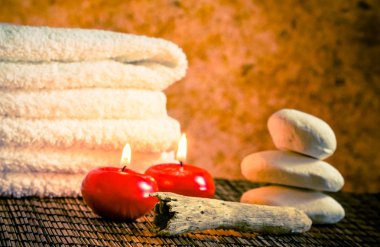 Spa Masaj sınır arka plan ile taş yığılmış havlu ve sıcak bir atmosfer kırmızı mumlar