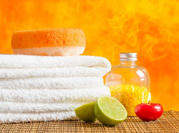 Wellness massage grens achtergrond met handdoek gestapeld, Rode kaars en kalk — Stockfoto