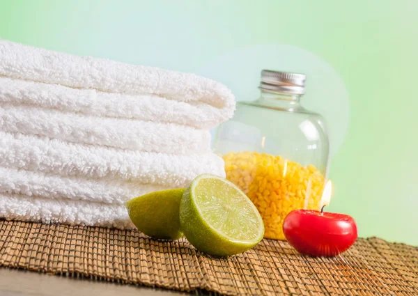 Spa massage gränsen bakgrunden med handduk staplade, rött ljus och lime — Stockfoto