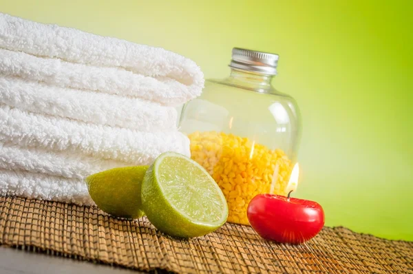 Spa massage bordure fond avec serviette empilée bougie rouge et citron vert — Photo