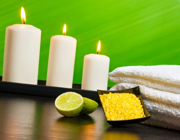 Spa massage border background with towel stacked sea salt candles and lime — Stock Photo, Image