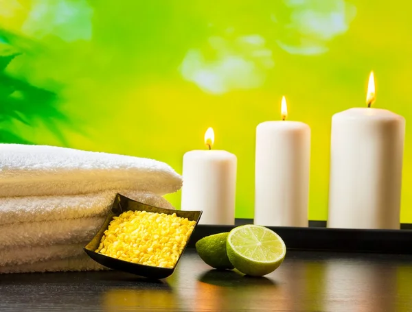 Spa massage border background with towel stacked sea salt candles and lime — Stock Photo, Image