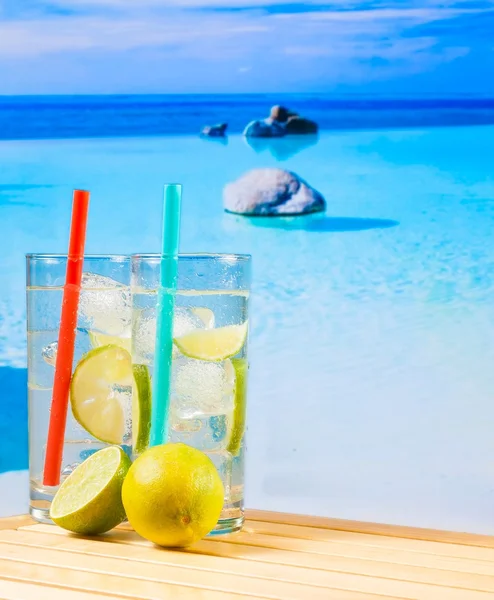 Twee glazen van cocktail met kalk slice op vervagen strand — Stockfoto