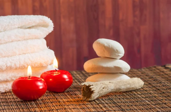 Fondo de borde de masaje spa con piedra apilada toalla y velas rojas ambiente cálido — Foto de Stock