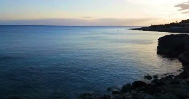 Gün batımında güzel, ünlü sahil sakin deniz, yazın çok popüler, kumlu sahil harika bir İbiza adası manzarası var..