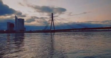 Gün batımında deniz üzerindeki Riga köprüsü, seyahat ve...