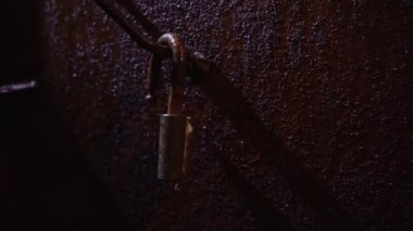 Eski paslı metal kapıdaki asma kilit. Koyu renk lekeler. Uzayı kopyala.