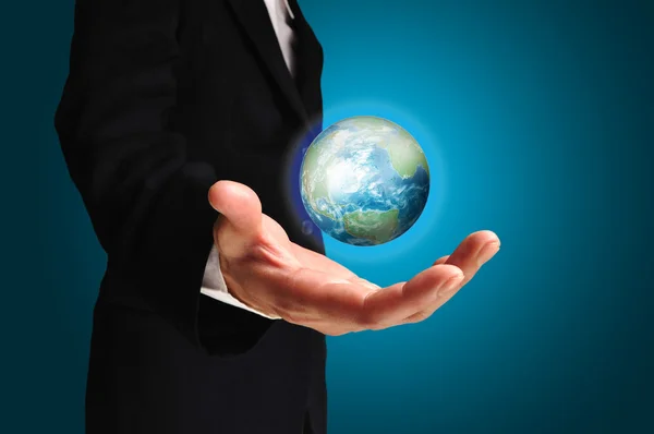 Un homme d'affaires tient la Terre dans une main — Photo