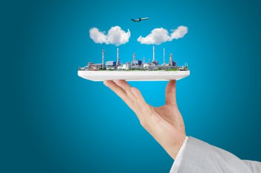 iş adamı tutun dokunmatik yüzey veya tablet ile petrol rafineri tesisi, bir