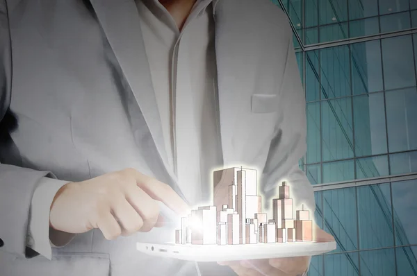 Man in suit holding tablet pc and city in the hand — Stock Photo, Image