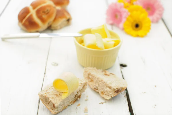 Hot cross buns, butter, flowers — Stock Photo, Image