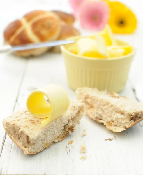 Pães de cruz quente, manteiga, flores — Fotografia de Stock