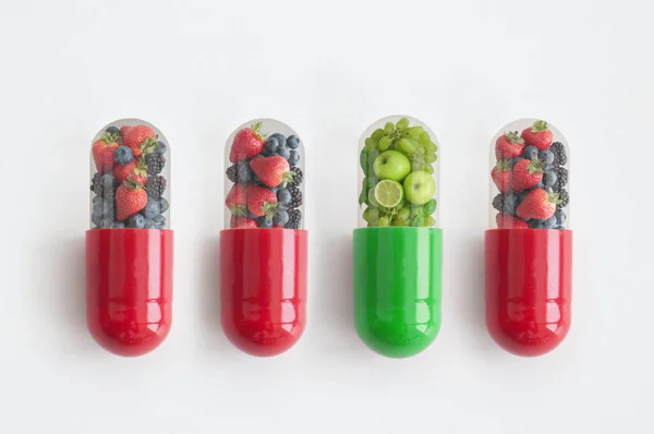 绿色胶囊 水果和蔬菜突出在红色浆果胶囊中 — 图库照片