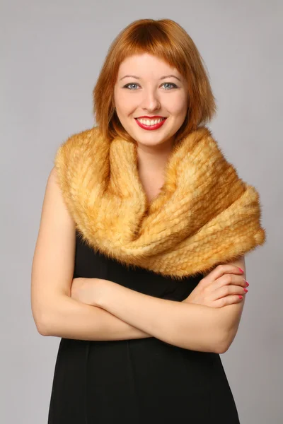 Retrato de una hermosa mujer sonriente con una bufanda de piel —  Fotos de Stock