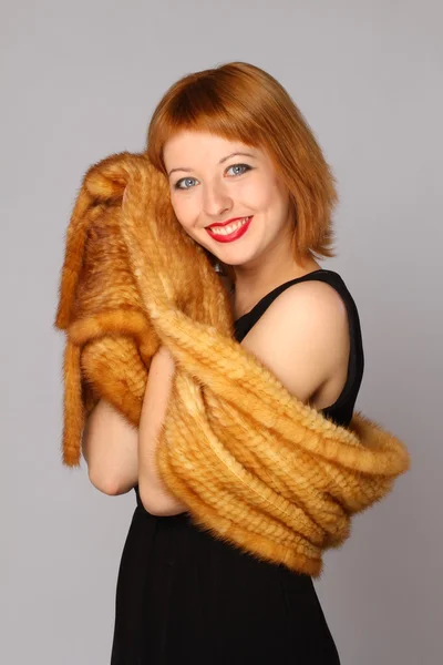 Retrato de una hermosa mujer sonriente con una bufanda de piel — Foto de Stock