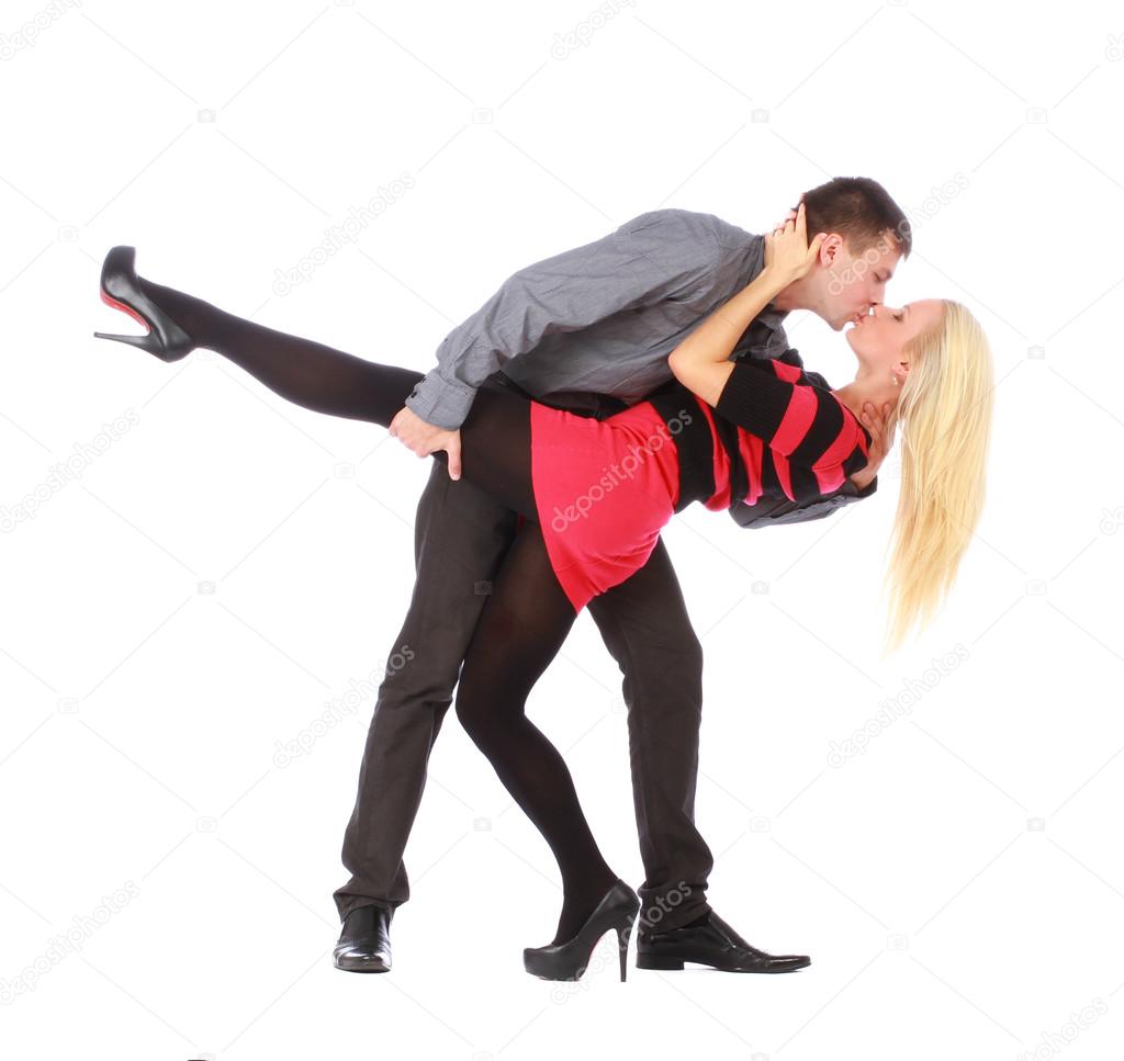 Young couple on dancing pose is kissing, isolated on white
