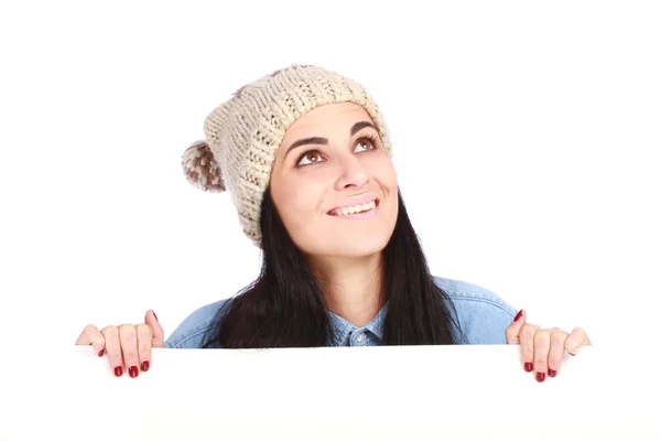 Jovem bela adolescente com um chapéu escondido atrás de um outdoor — Fotografia de Stock