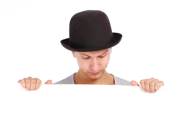 Young teenage boy hiding behind a billboard and making a face looking down — Stock Photo, Image