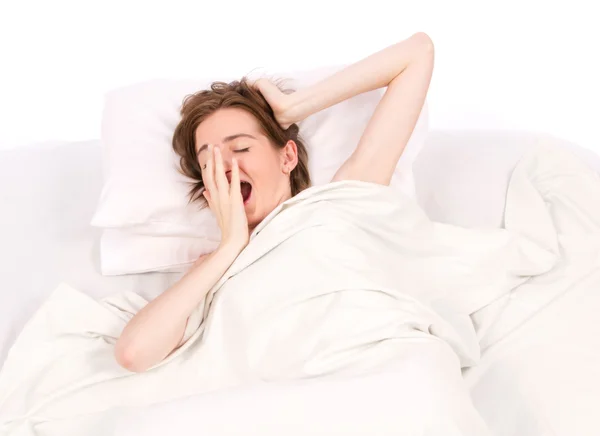 Jeune femme bâillant au lit — Photo