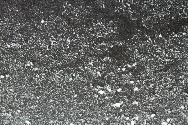 Białe płatki śniegu na ziemi czarnej — Zdjęcie stockowe