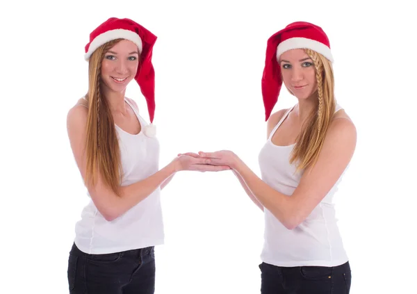 Twee tweelingzusjes in santa hoeden — Stockfoto