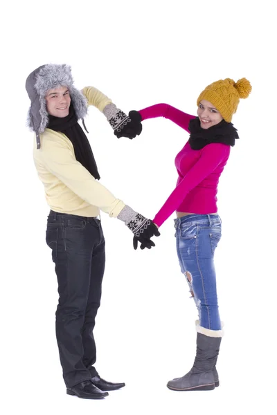 Couple in winter clothes making heart shape Stock Photo